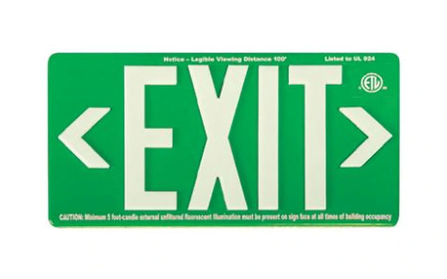Photoluminescent exit sign glowing in a dark commercial hallway.
