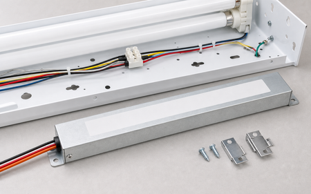 Low-profile emergency ballast staged with slim fluorescent fixture
